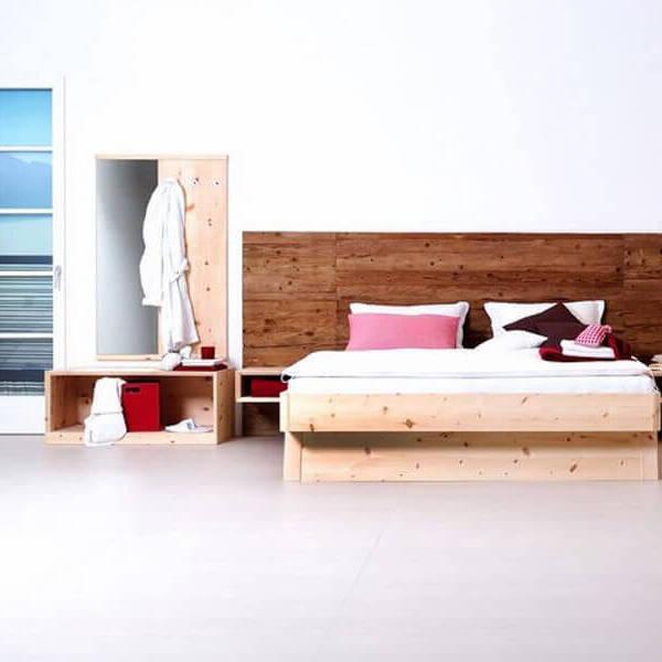 Impression eines Schlafzimmers mit einem Holzbett und einer Kommode