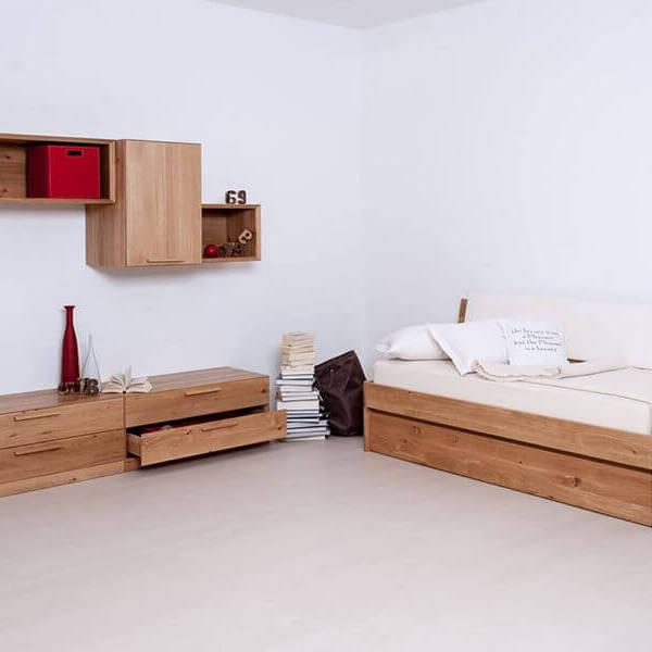 Impression eines Schlafzimmers mit einem Holzbett und einem Sideboard