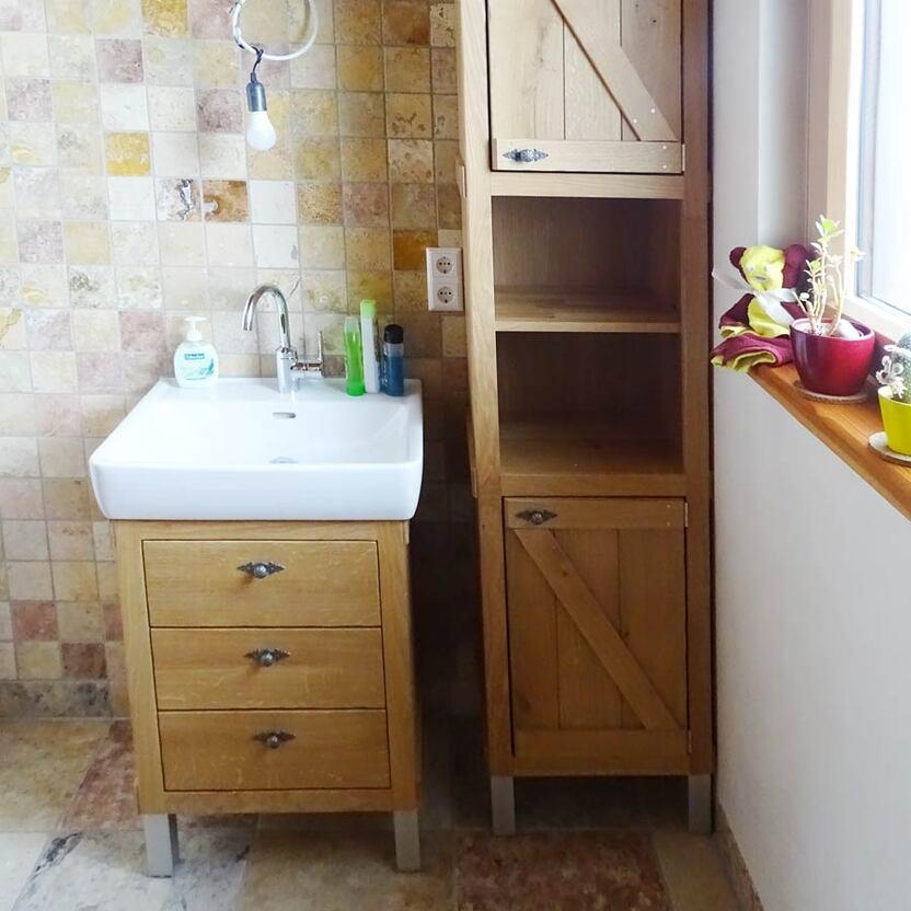 Impression eines Badezimmers mit einem Waschbeckenunterschrank und einem Regal aus Holz