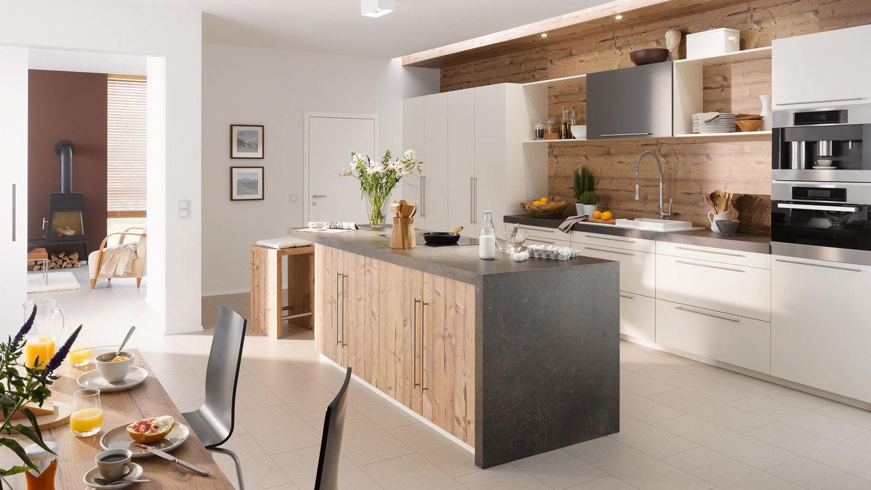 Impressionen einer Küche mit Esszimmer mit hellen Holzmöbeln und dunklen und weißen Fronten im Kontrast