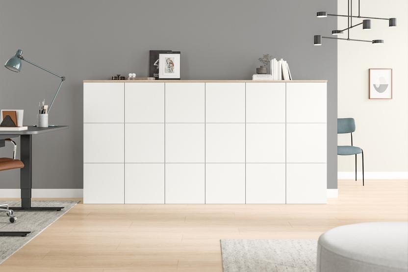 Maßgefertigte, weiße Kommode mit sauberer Linienführung und minimalistischem Stil, stehend auf einem hellen Holzboden.